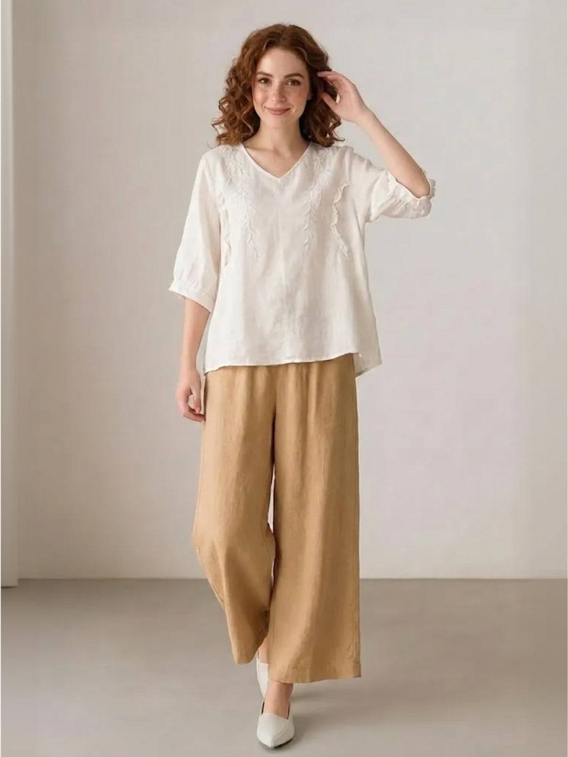 Woman wearing 100% cotton linen blend golden hour set with embroidered V-neck top and wide-leg trousers