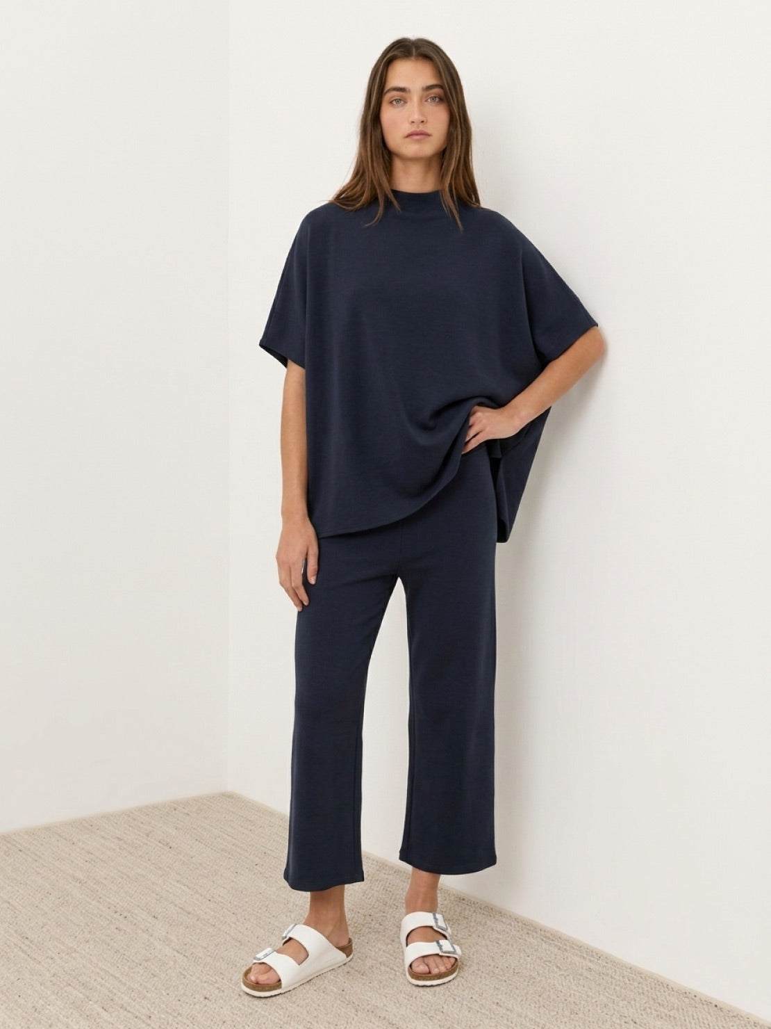 Woman wearing a cotton-blend capelet lounge set with mock neck capelet top and wide-leg pants