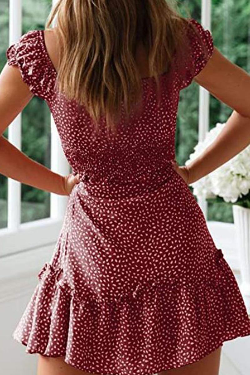 Back view of a woman wearing a red sweetheart collar printed ruffled maxi dress with white polka dots