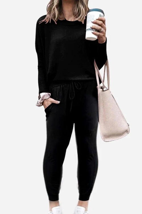 woman wearing black Cozy Chic Two-Piece Sweatsuit holding coffee cup and beige tote bag