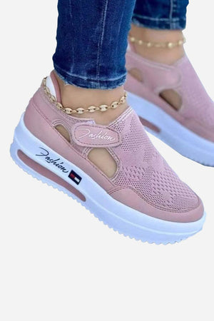 Pink breathable wedge sneakers with velcro closure and white non-slip sole, worn with jeans and anklet bracelet