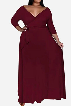 Elegant plus size dress with deep V-neck, 3/4 sleeves, belted waist, and swing skirt in solid burgundy color.