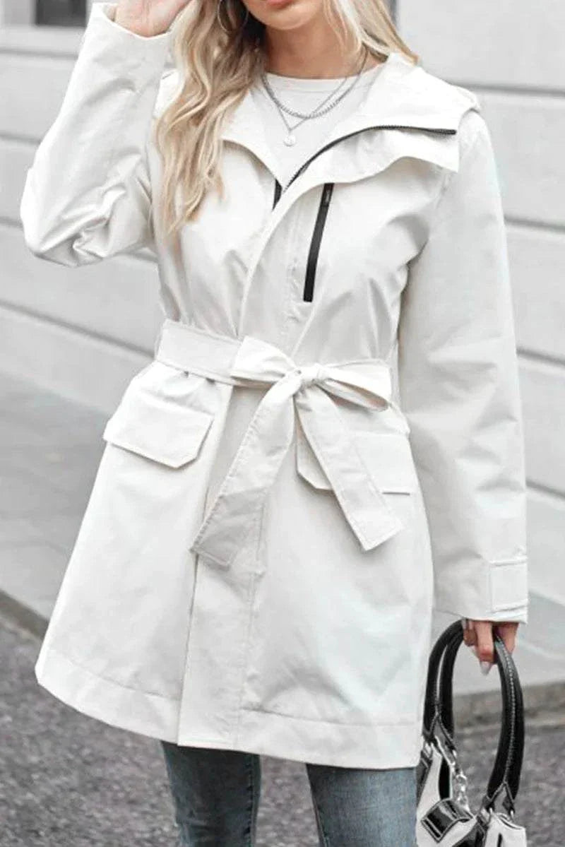 White water-resistant windbreaker trench jacket with belt and pockets worn by woman