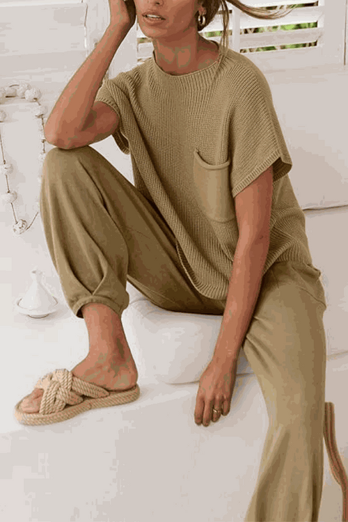 Woman wearing Comfy Couture Knit Sweater and matching high-waisted pants set in beige tones sitting casually indoors