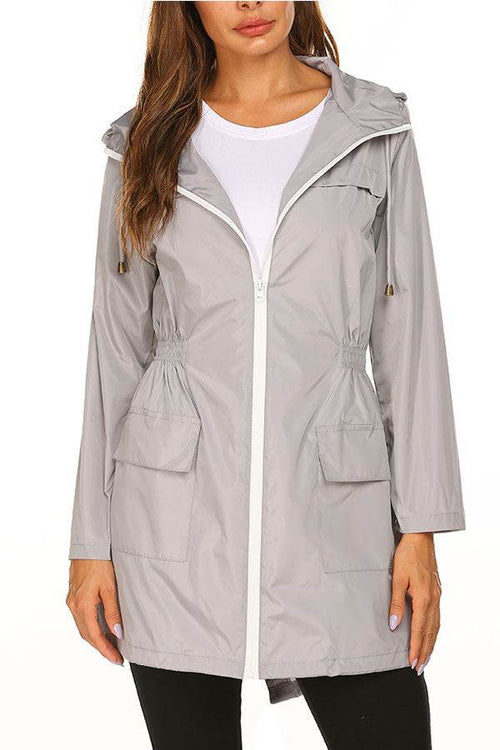 Lightweight gray hooded raincoat with zipper and pockets for outdoor and travel use