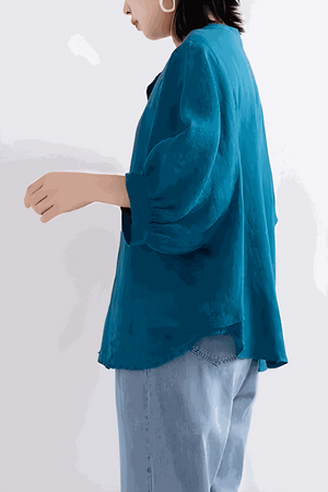 Relaxed loose breathable linen blouse in vibrant blue with long sleeves and a relaxed fit, styled with light denim jeans.