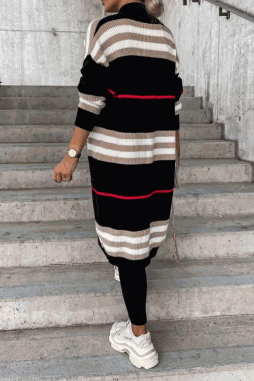 Cozy striped long knitted cardigan with oversized fit and soft fabric, black, beige, and red stripes, worn with black leggings and white sneakers.