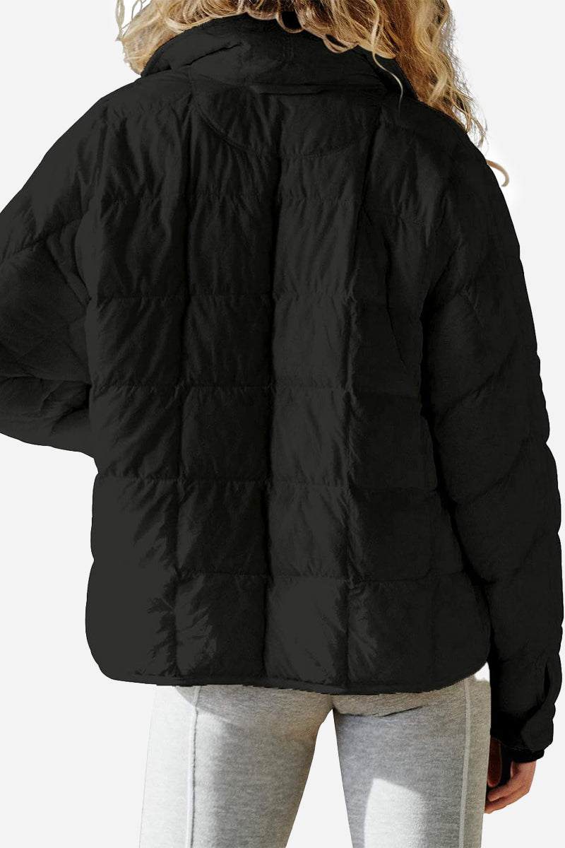 Black lightweight puffer travel jacket with quilted design, worn by woman from the back.