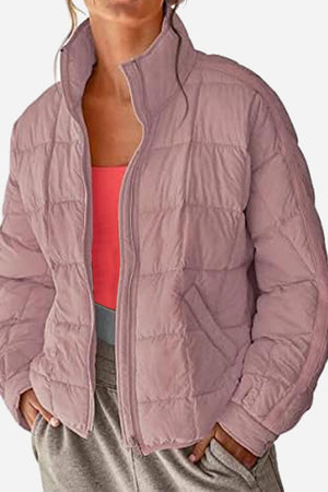 Lightweight puffer travel jacket in mauve color worn with casual outfit, warm and packable design