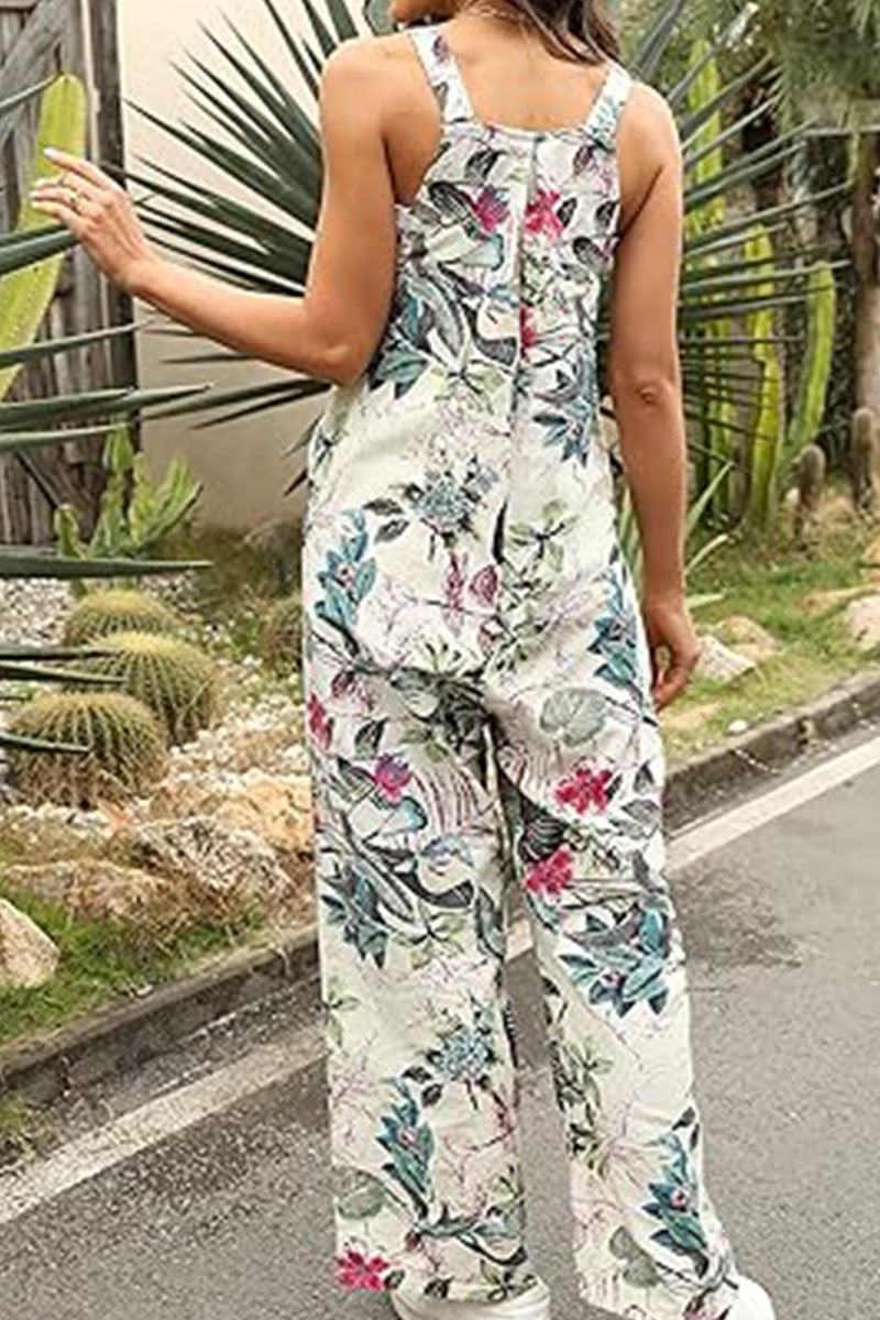 Back view of woman wearing floral printed Bohemian Fantasy Overalls in a garden setting