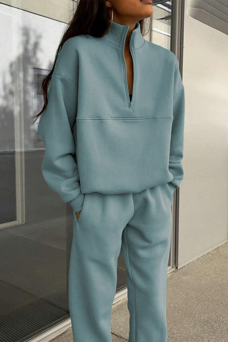 woman wearing light blue cotton-blended two-piece tracksuit with high collar and zipper standing outdoors