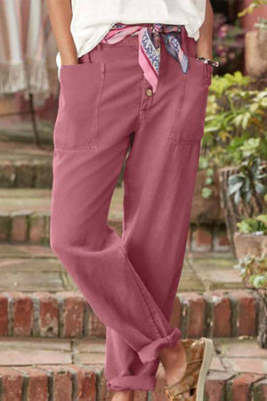 Woman wearing pink casual button-down utility-chic trousers with pockets and rolled cuffs