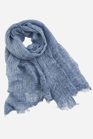 Lightweight linen scarf in soft blue with frayed edges, breathable and versatile accessory
