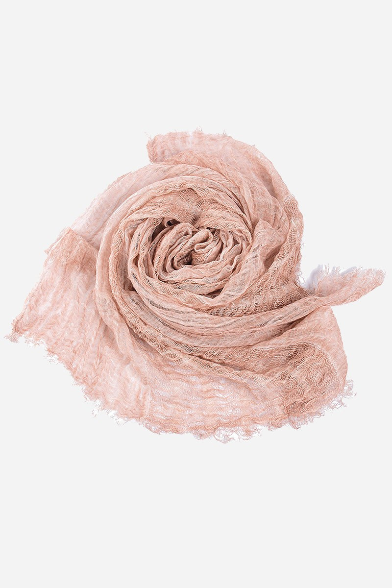 Lightweight linen scarf in soft pink with frayed edges rolled on white background