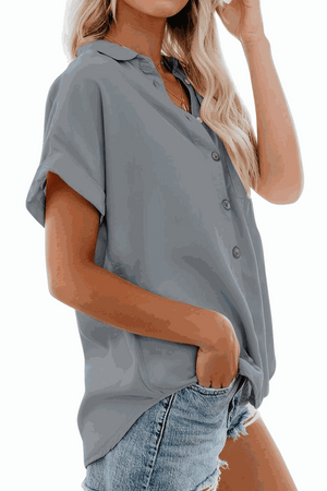 Grey V-neck collared button blouse with rolled short sleeves and casual fit worn with denim shorts