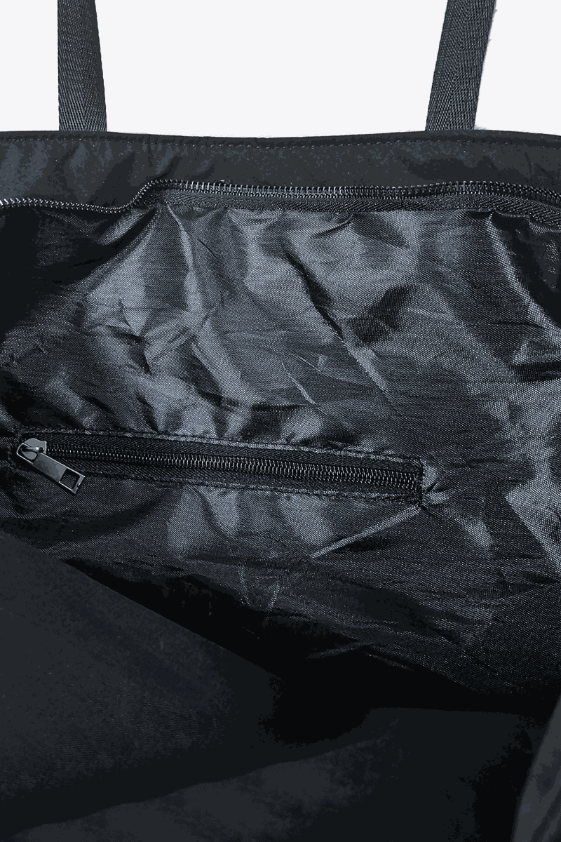 Interior view of black waterproof travel bag with zippered pockets and durable fabric lining