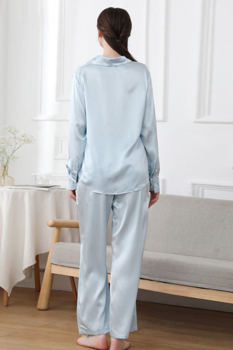 Back view of woman wearing light blue Mulberry Silk Sleepwear set in living room setting