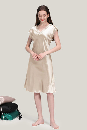 Woman wearing a luxurious beige Mulberry Silk V-Neck Nightgown standing barefoot against a plain background