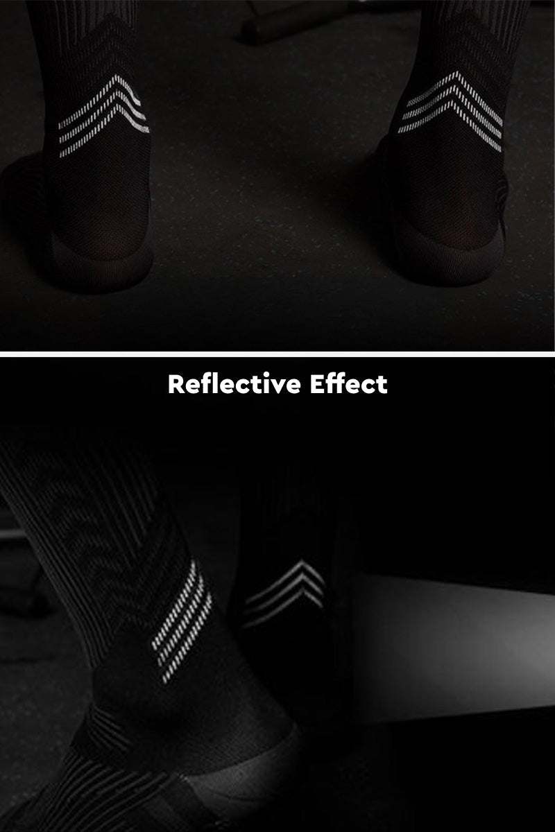 Black premium compression socks with reflective stripes showing reflective effect in low light
