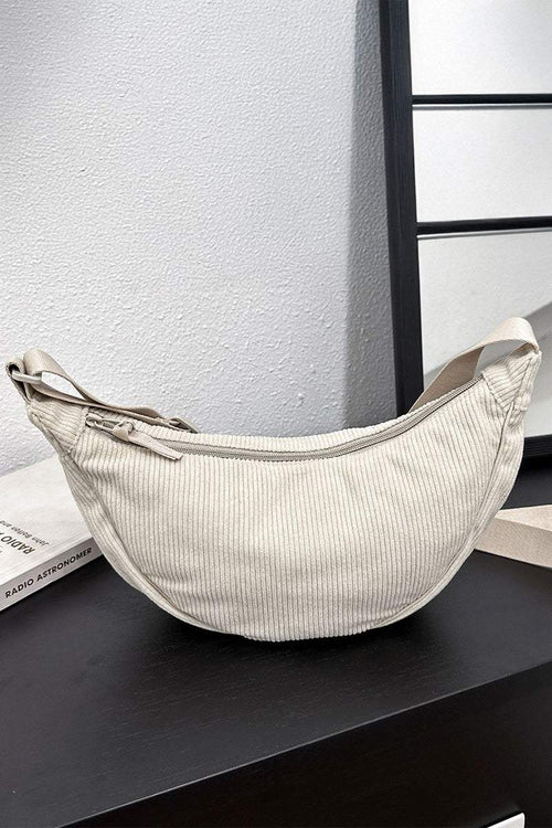 Beige corduroy shoulder bag with adjustable strap and zip closure, soft ridged texture, lightweight and roomy design.