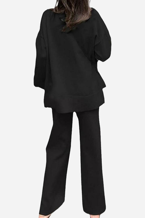 Woman wearing black knitted turtleneck two-piece set with loose top and wide-leg pants back view