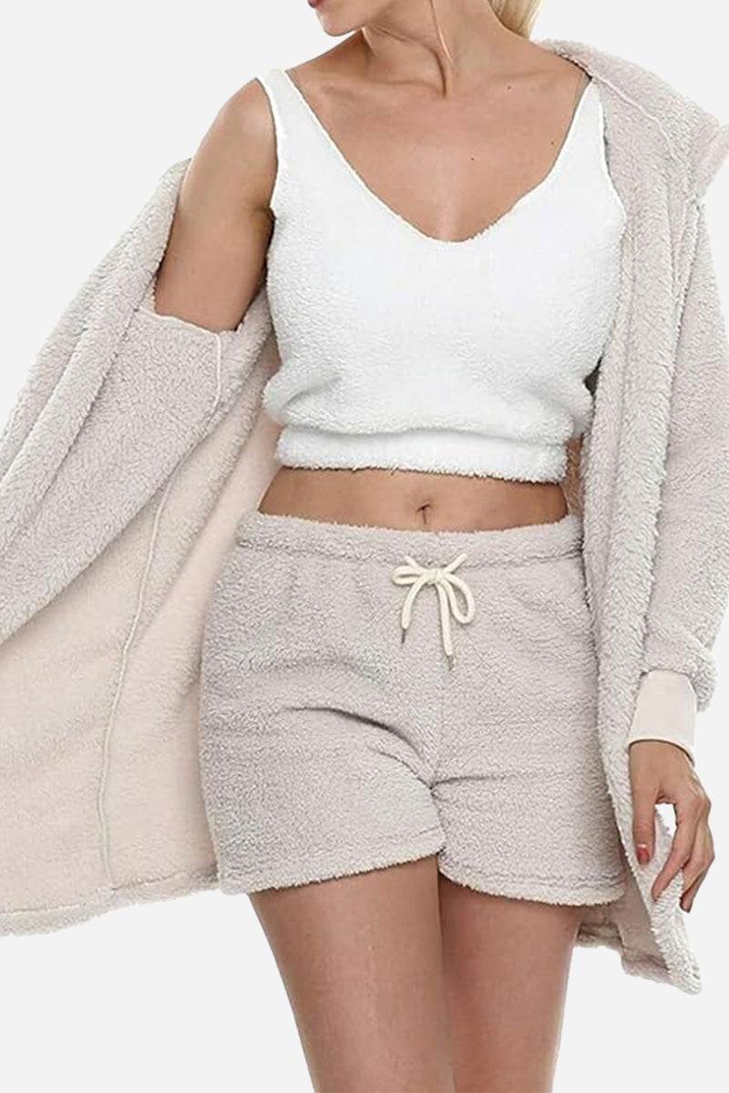 Woman wearing Cloud Soft 4-Piece Collection cozy beige shorts, white crop top, and matching plush cardigan.