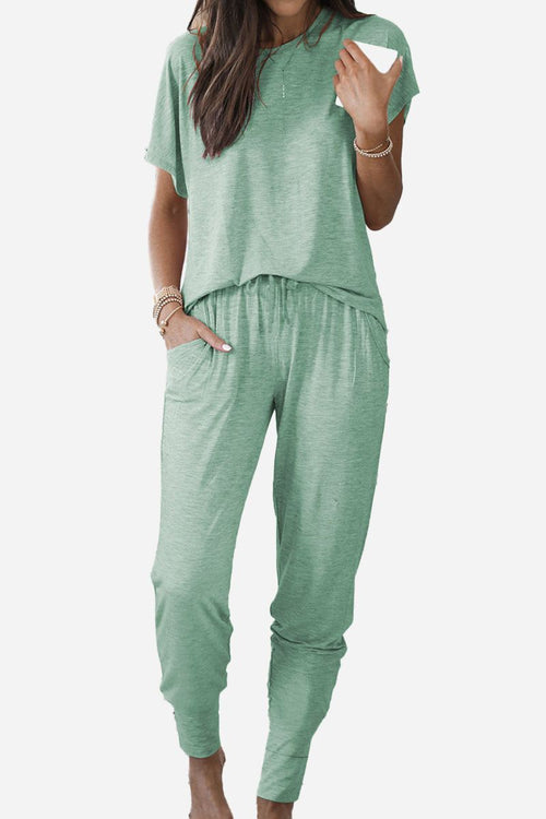 Woman wearing ultra-soft two-piece loungewear set in green with batwing sleeves and jogger pants with pockets.