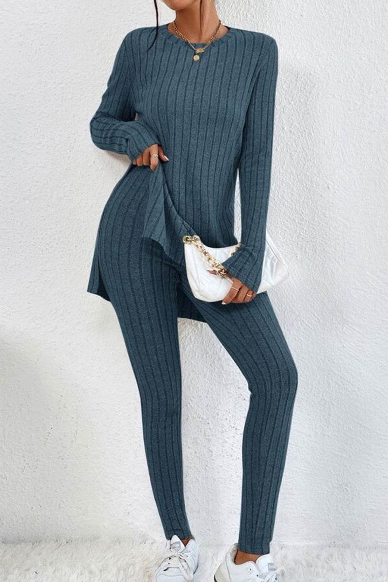 Woman wearing Butter Touch Ribbed Two-Piece Set in blue ribbed fabric with long-sleeve top and fitted pants holding white handbag