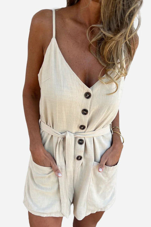 Woman wearing 100% pure linen breathable natural comfort jumpsuit with button front, adjustable waist tie, and pockets in beige color