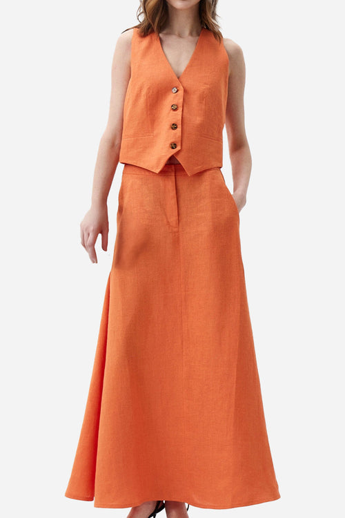 Woman wearing cotton-linen blend Mediterranean sunset orange two-piece with sleeveless vest and flowing skirt