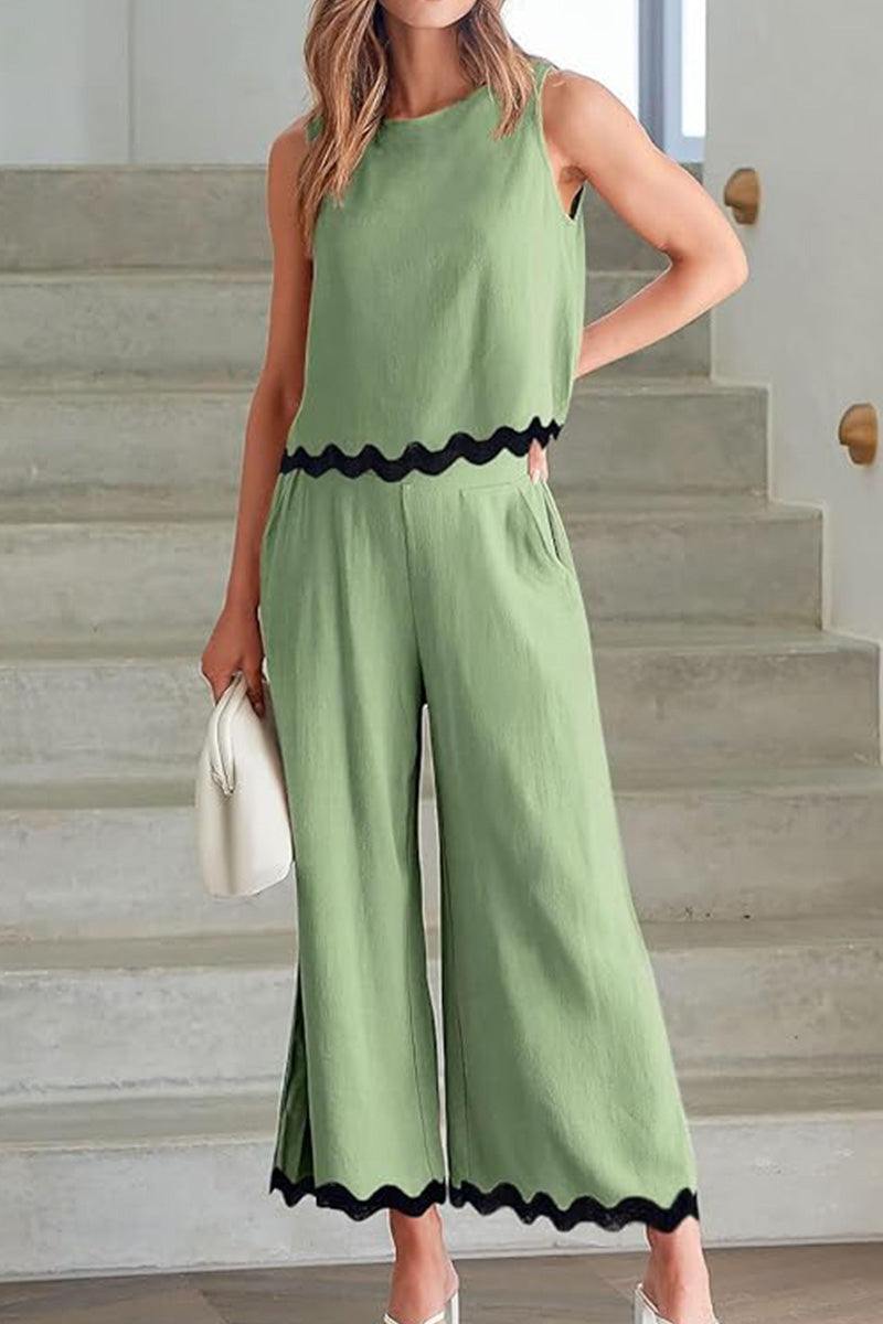 Woman wearing green scalloped trim sleeveless top and wide leg pants set with pockets and elastic waistband