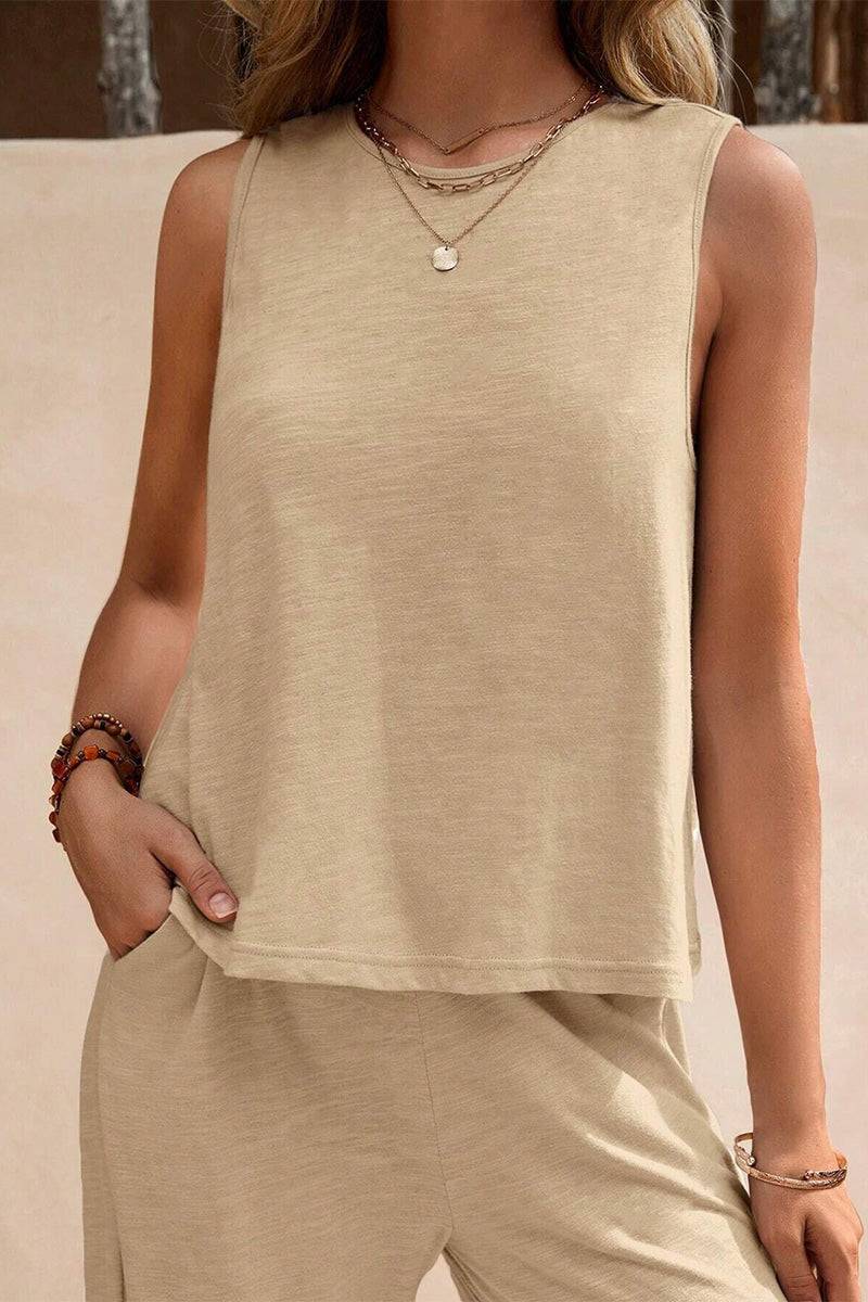 Woman wearing beige sleeveless wide leg pants set with layered necklaces and bracelets