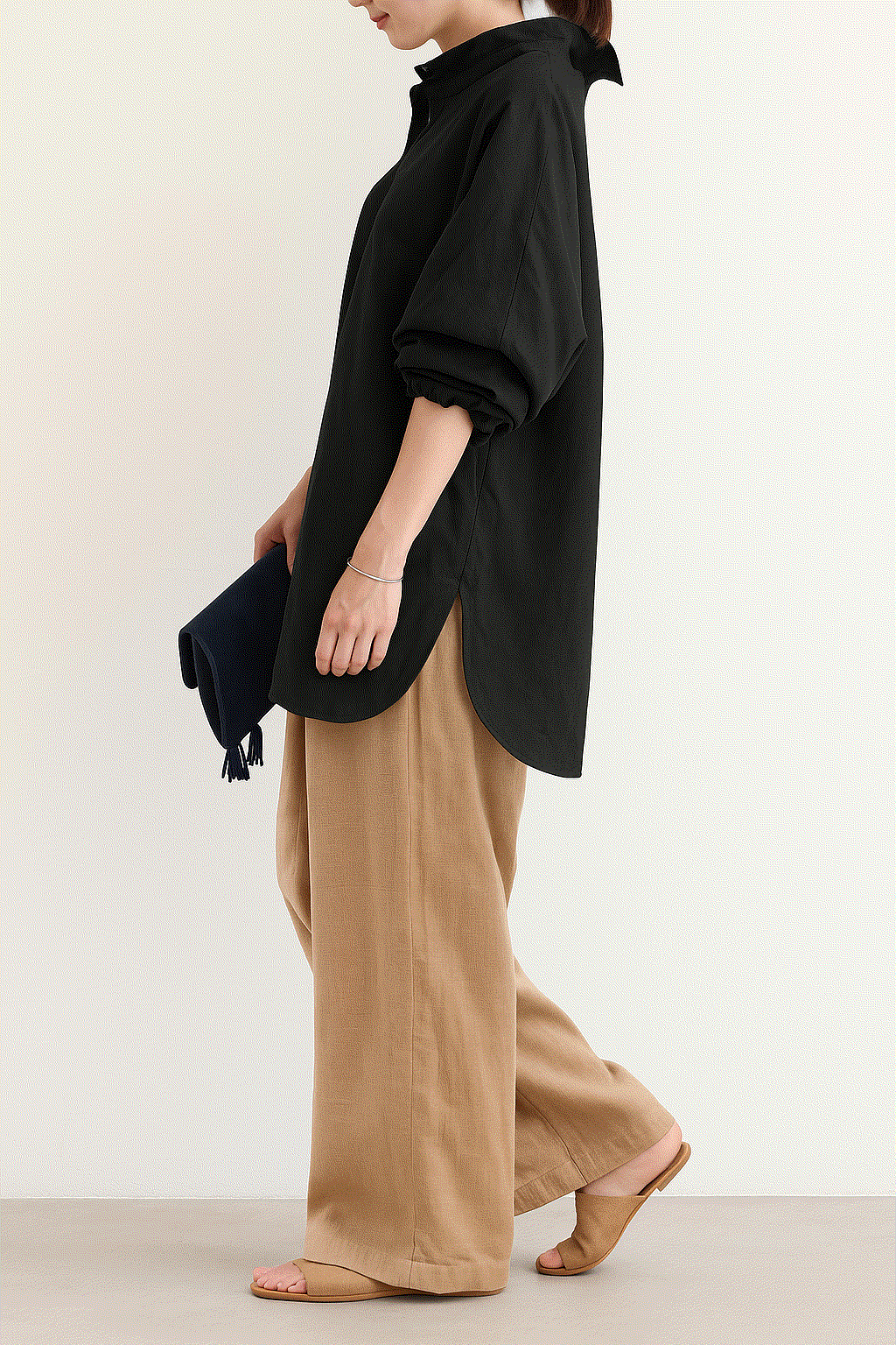 Woman wearing Linen Breeze Set with black oversized shirt and beige high-waist linen-cotton blend pants