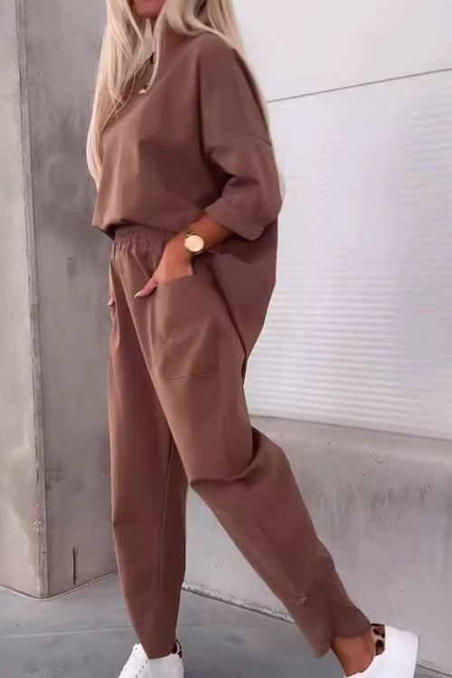 Woman wearing brown relaxed fit two-piece set with crew neck sweatshirt and jogger pants with side pockets