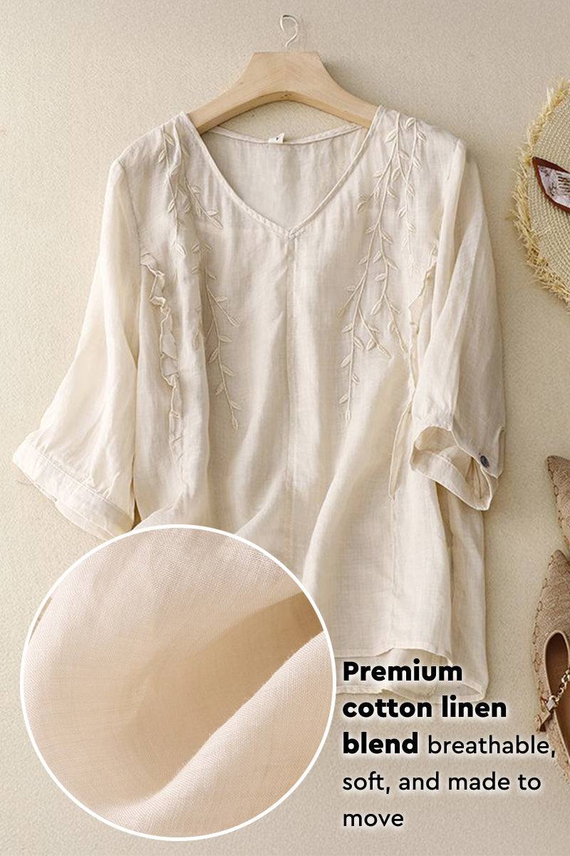Cream cotton linen blend blouse with embroidered V-neck and three-quarter sleeves on hanger