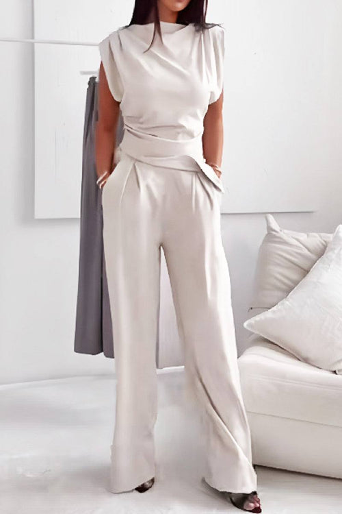 Woman wearing Manhattan Lines Draped two-piece set with asymmetrical draped sleeveless top and wide-leg palazzo pants in light beige