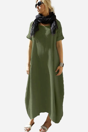 Woman wearing a green Breeze Cocoon Dress with rolled sleeves and a black scarf.