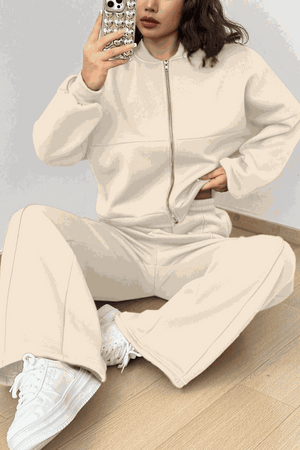 The Voyager Zip Set cream zip-front sweatshirt and wide-leg joggers travel outfit with pockets and white sneakers