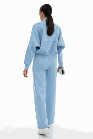 Woman wearing light blue The Voyager Zip Set with zip-front sweatshirt and wide-leg joggers, back view