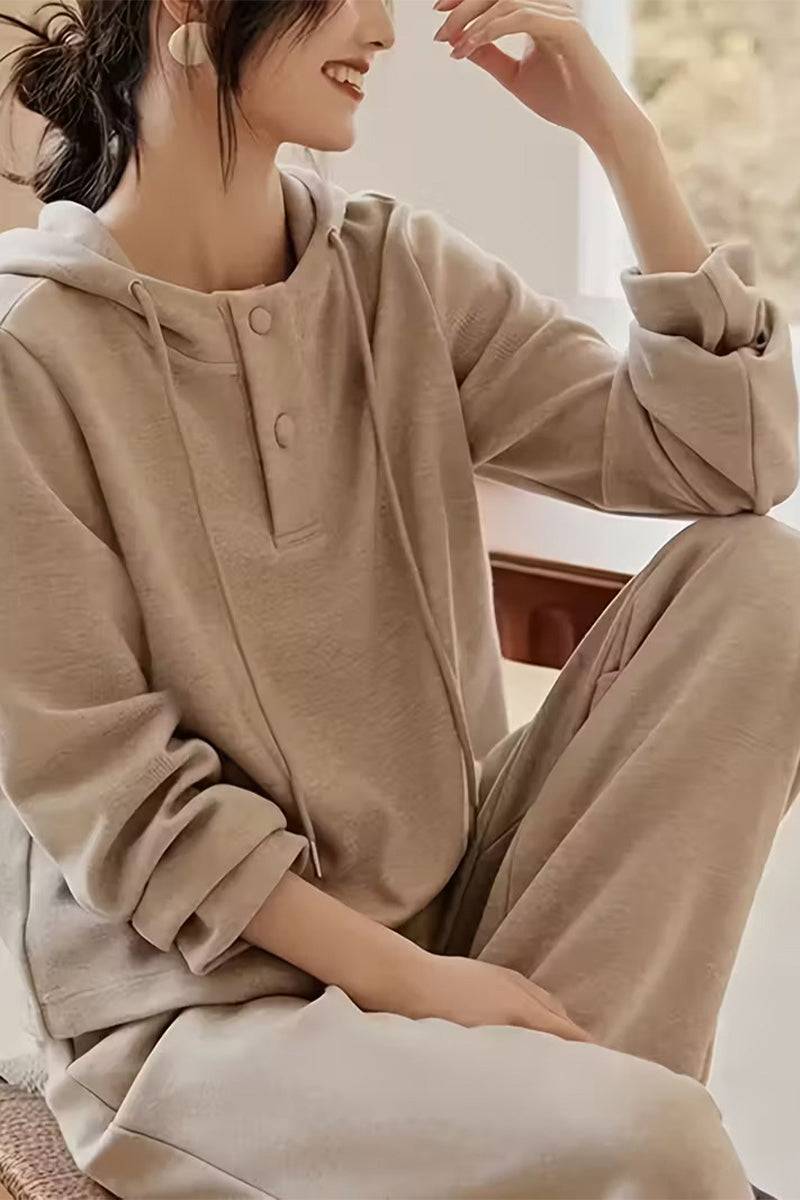 Woman wearing beige Quiet Comfort Everyday two-piece ribbed knit set with henley hoodie and wide-leg pants lounging indoors