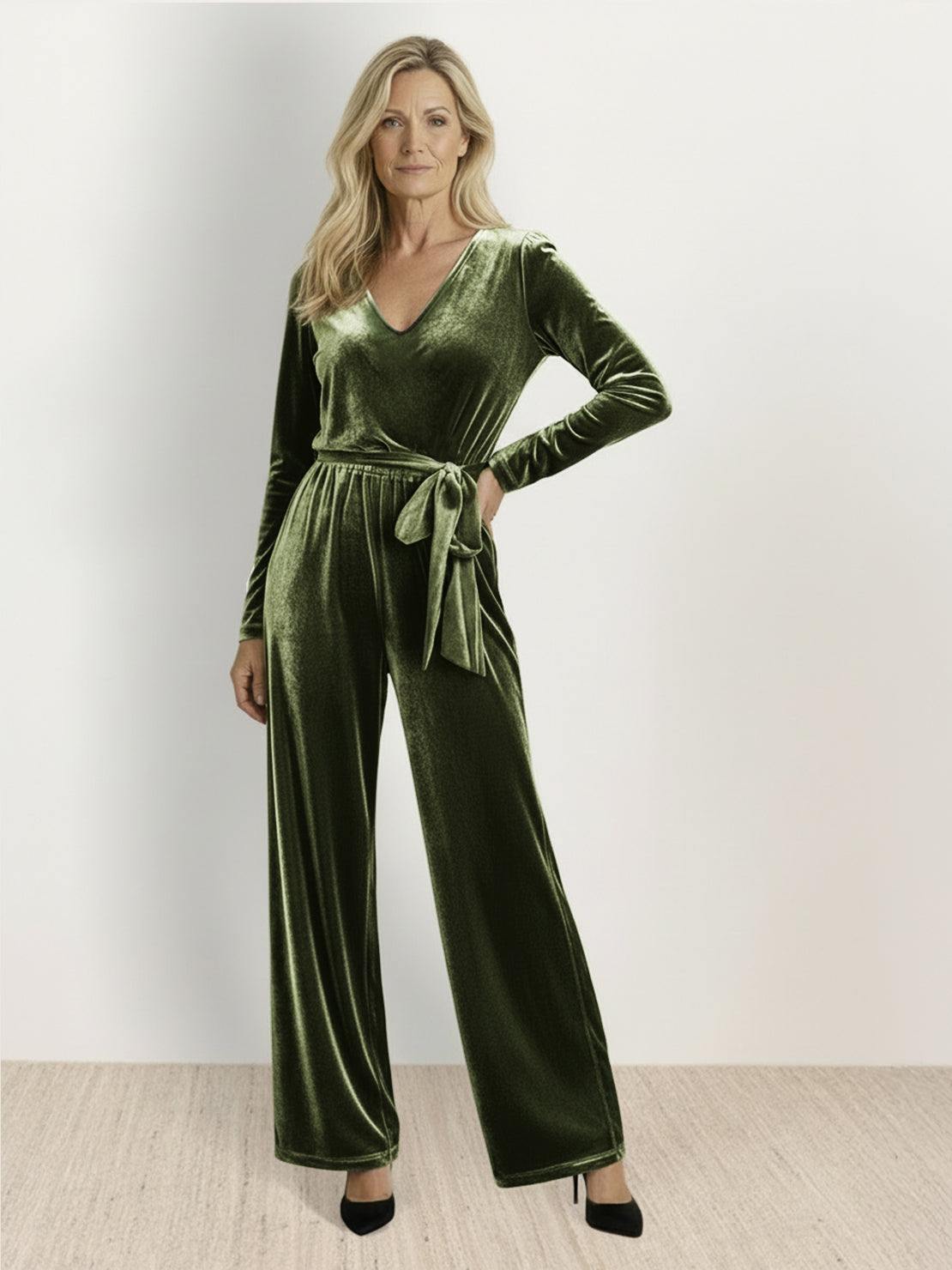 Woman wearing a deep V-neck velvet suit with long sleeves, removable waist tie, and wide-leg pants with side pockets