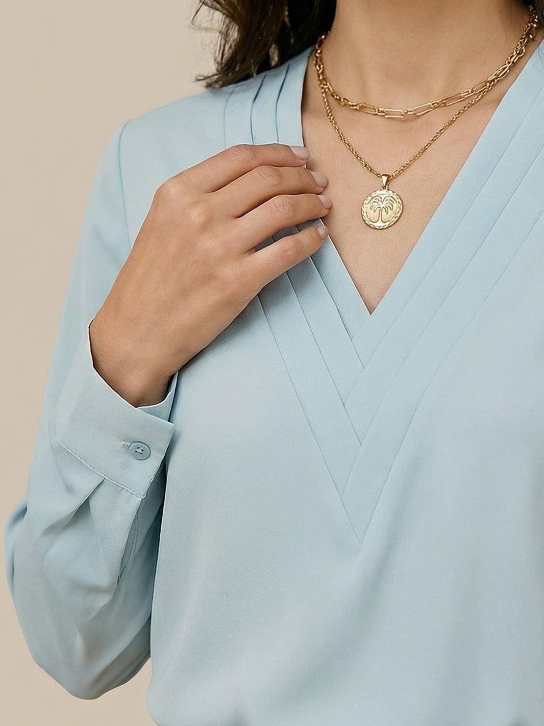 White pleated V-neck long-sleeve blouse with button cuffs and relaxed fit