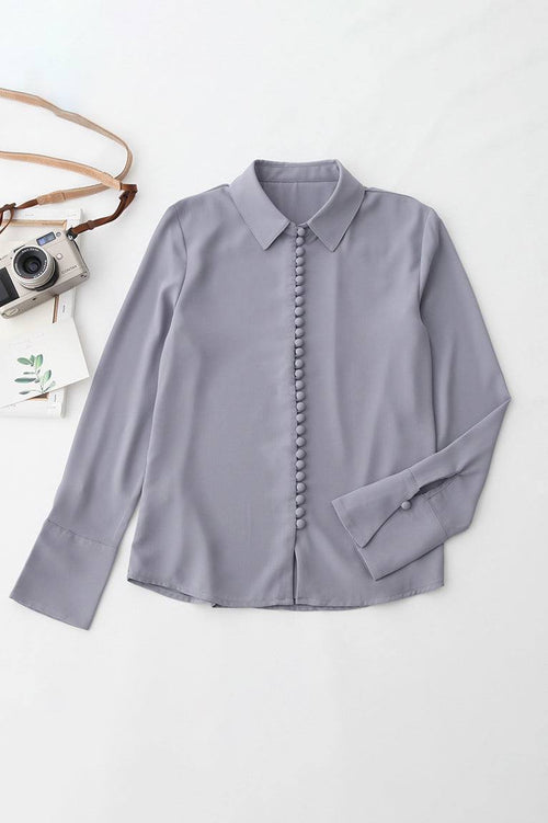 Bayam Blouse in soft gray with button-down front and classic collar, long sleeves, made of 100% polyester.