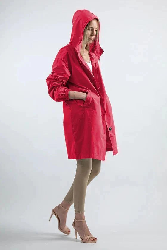 Woman wearing a red water-resistant oversized hooded windbreaker rain jacket with pockets and elastic cuffs