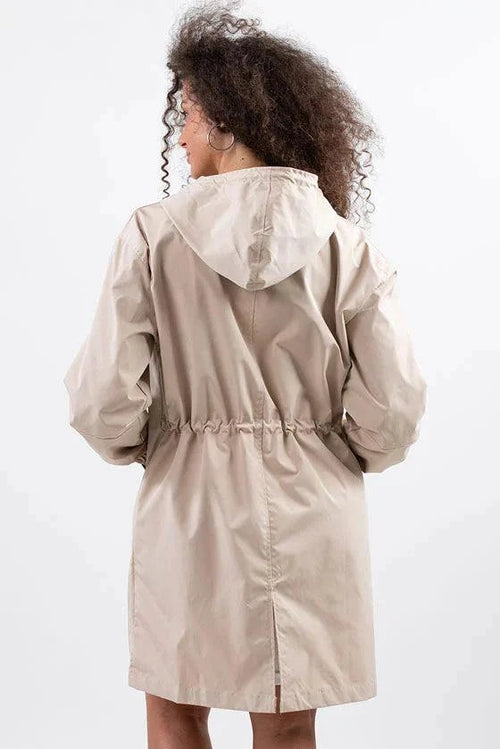 Back view of beige oversized water-resistant windbreaker with hood and adjustable waist