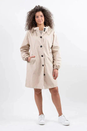 Water Resistant Oversized Windbreaker rain jacket beige with hood and buttons, model wearing white sneakers