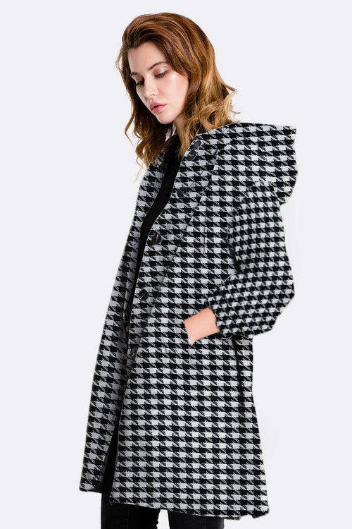 Woman wearing black and white houndstooth water-resistant oversized hooded windbreaker jacket