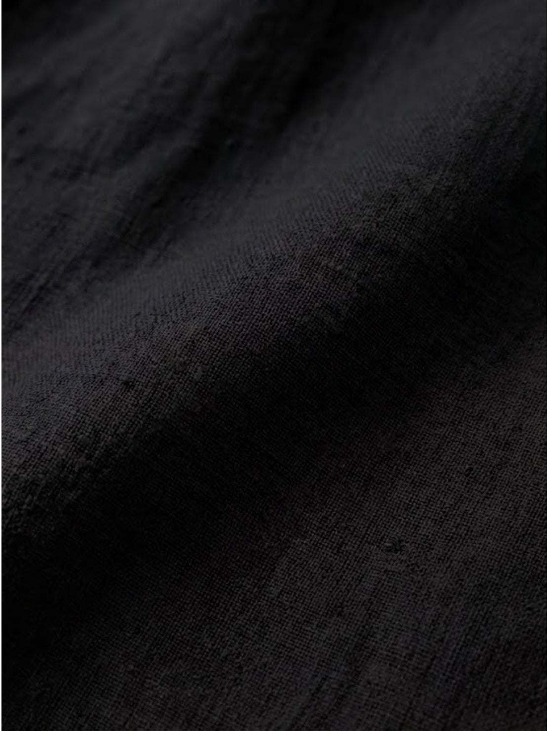 Close-up of soft black pure linen fabric for age-defying button detail shirt