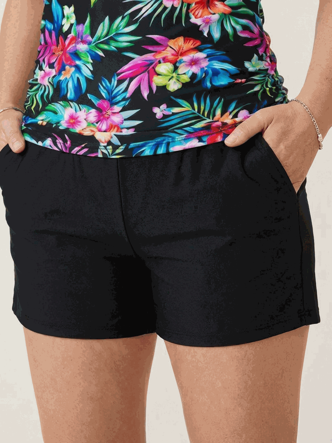 woman wearing high-neck ruched tankini set with gathered side seams and soft built-in brief at beach