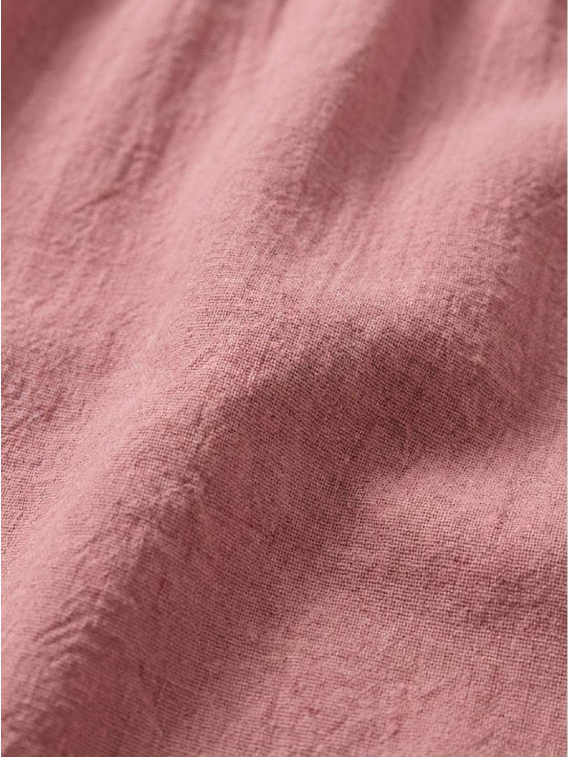 Woman wearing capped-sleeve voluminous pleated midi dress with pockets and flowing skirt